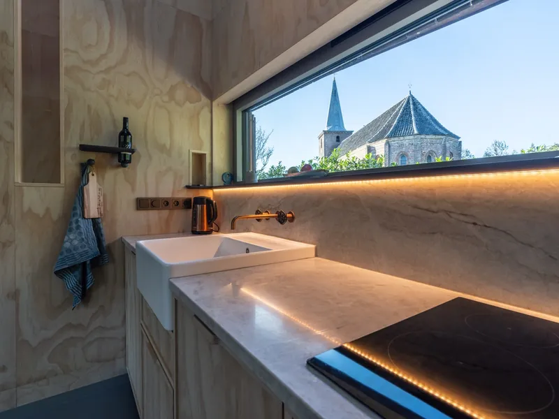 Kitchen with a long window looking out on the church of Hoorn
