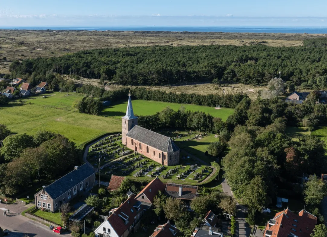 Luchtfoto van Hoorn met de kerk, de duinen en de Waddenzee