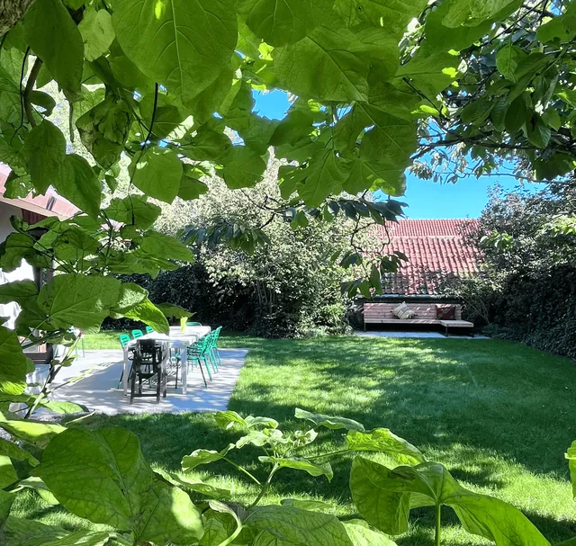 De tuin met gazon, terras en tuintafel