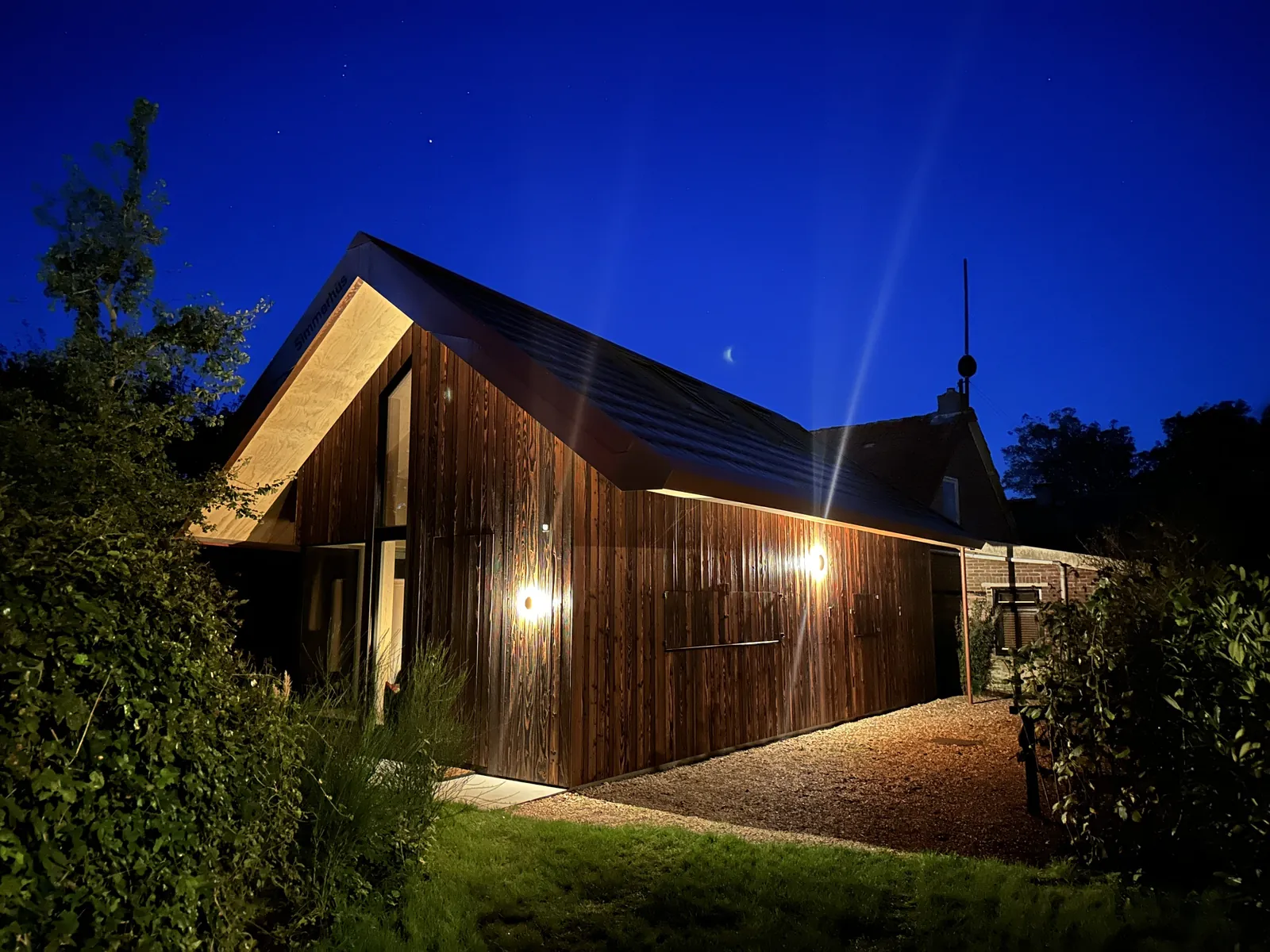 Simmerhûs at night, its wooden façade lit up