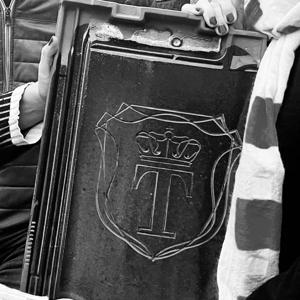 Handgemaakte dakpan van Koninklijke Tichelaar met kroon en T